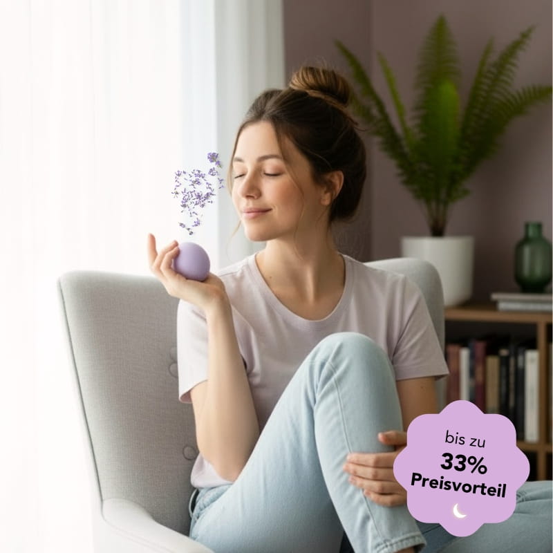 Frau riecht mit geschlossenen Augen an der Zendou Duftknete, Lavendelblüten steigen zu ihr auf.