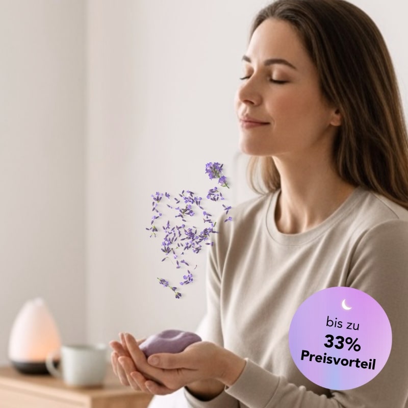 Frau atmet mit geschlossenen Augen entspannt durch und hält dabei die Zendou Duftknete in beiden Händen, aus der Lavendelblüten zu ihr aufsteigen.